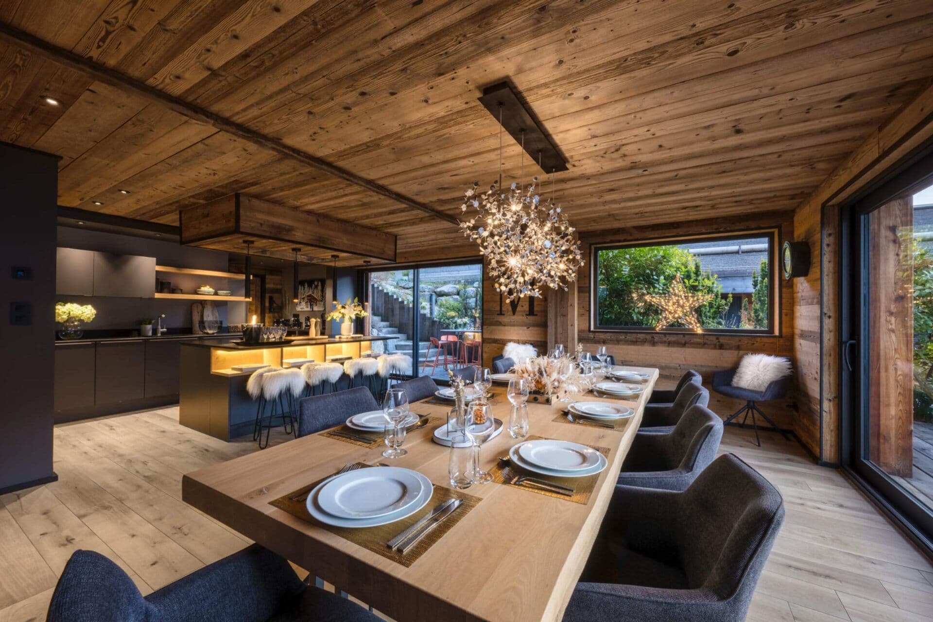 Open-plan dining area with a table set for 12 beside the kitchen