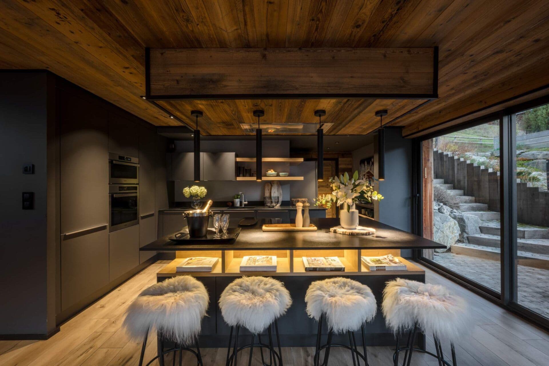 Open-plan kitchen and dining area with island seating and terrace access