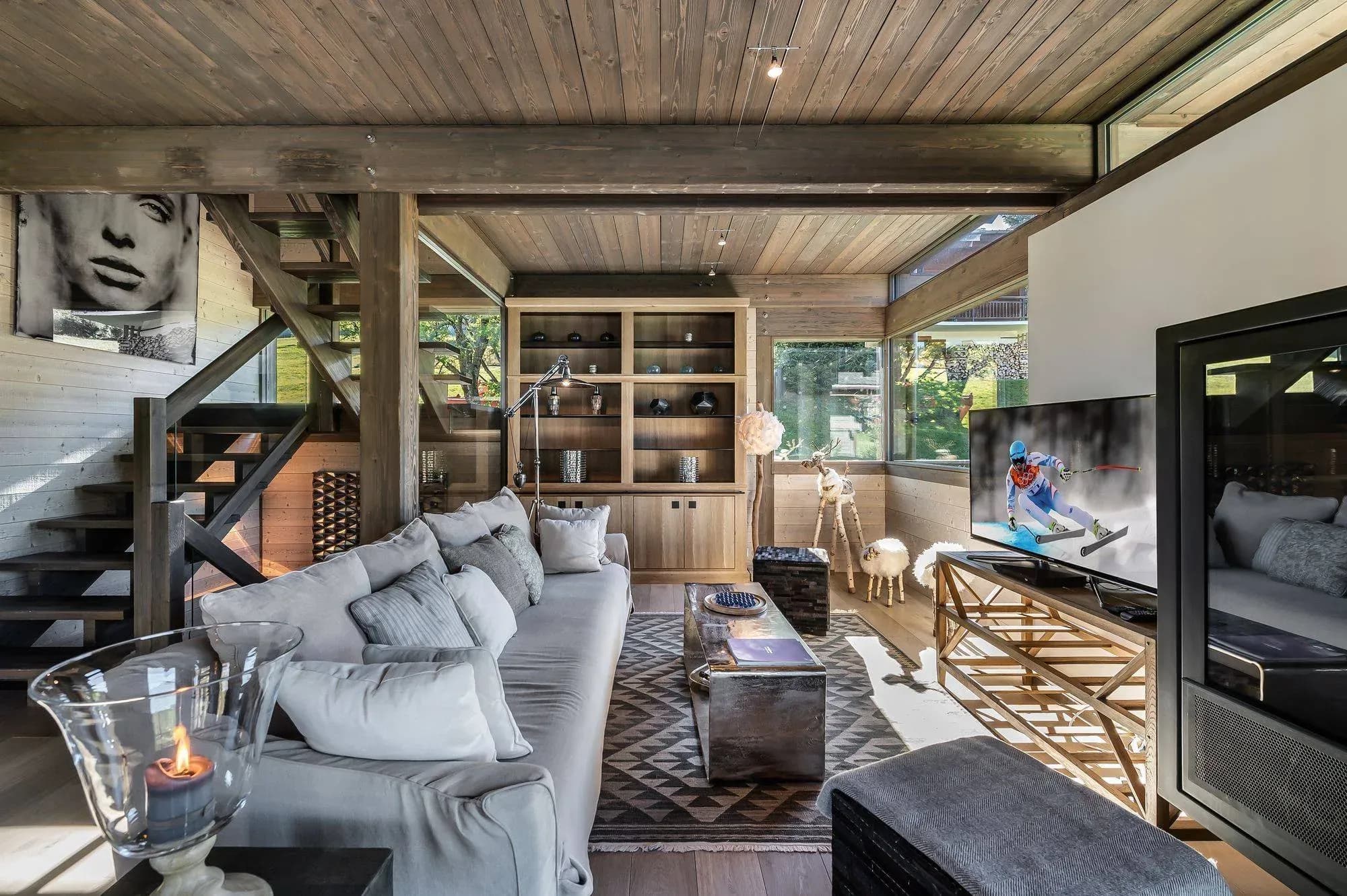 Living room with grey sofa, TV and open wooden staircase