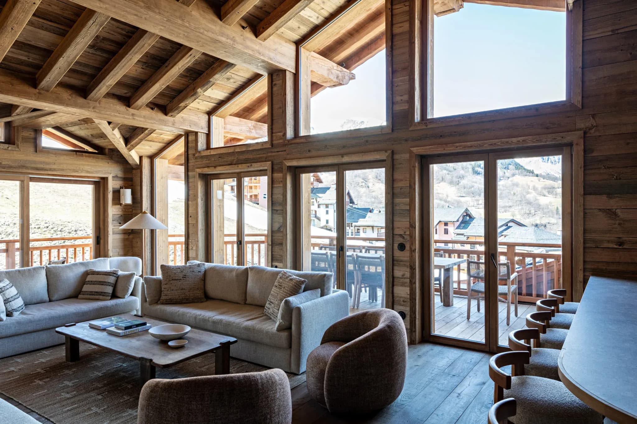 Living room with two sofas, armchairs and balcony doors to mountain views