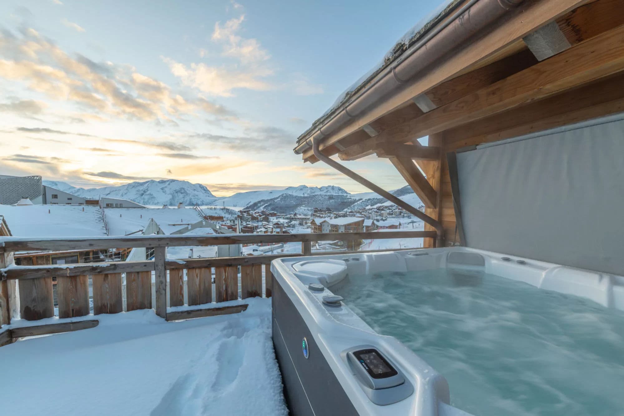 Outdoor Jacuzzi on the snowy terrace with panoramic mountain views