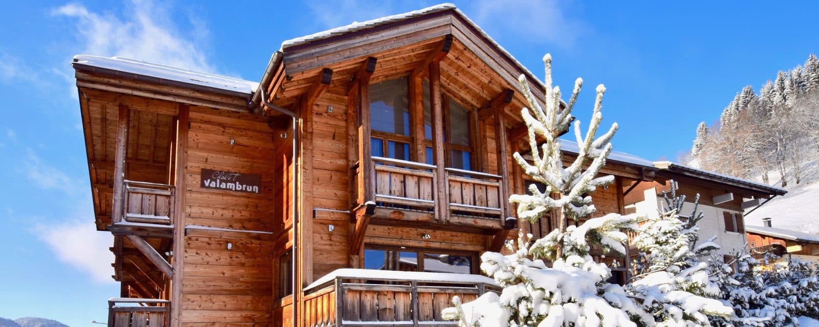 Snow-covered timber chalet exterior with several balconies