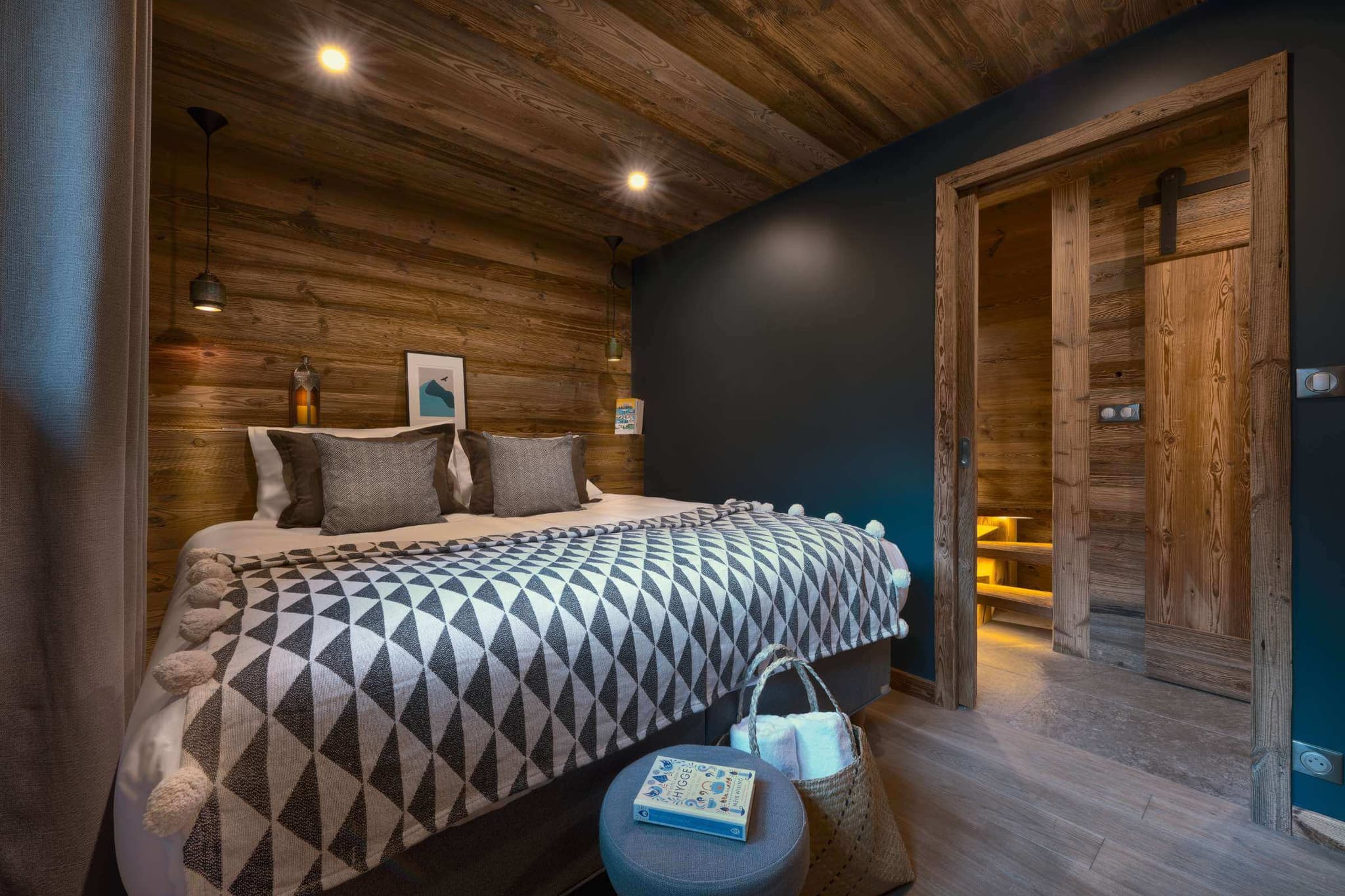 Double bedroom with timber walls and bedside lighting