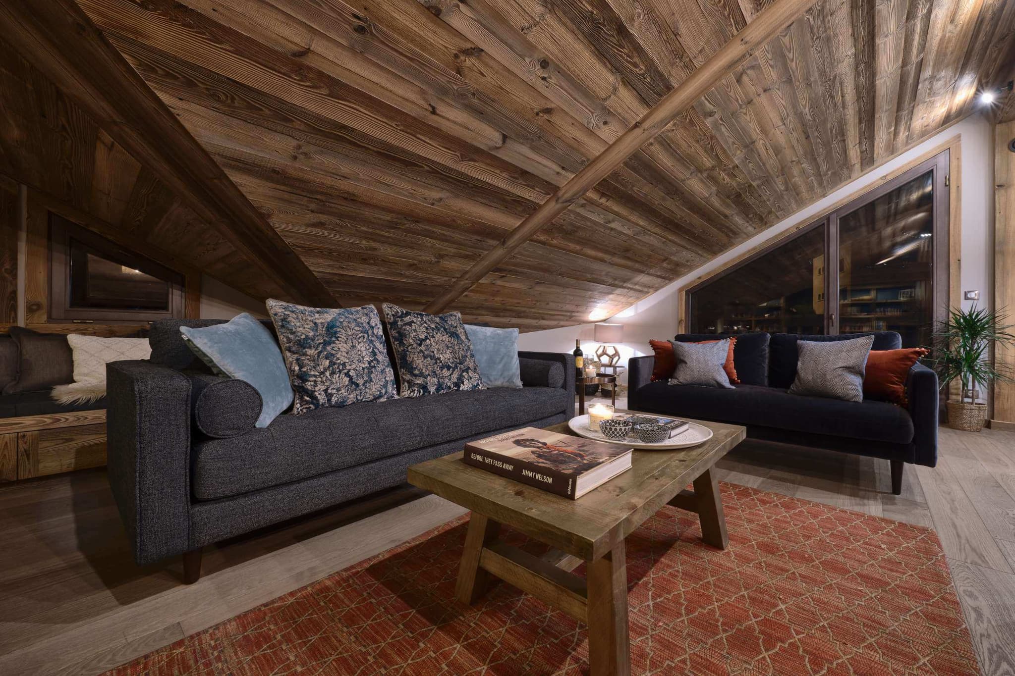 Living area with sofas, a coffee table and timber-lined walls