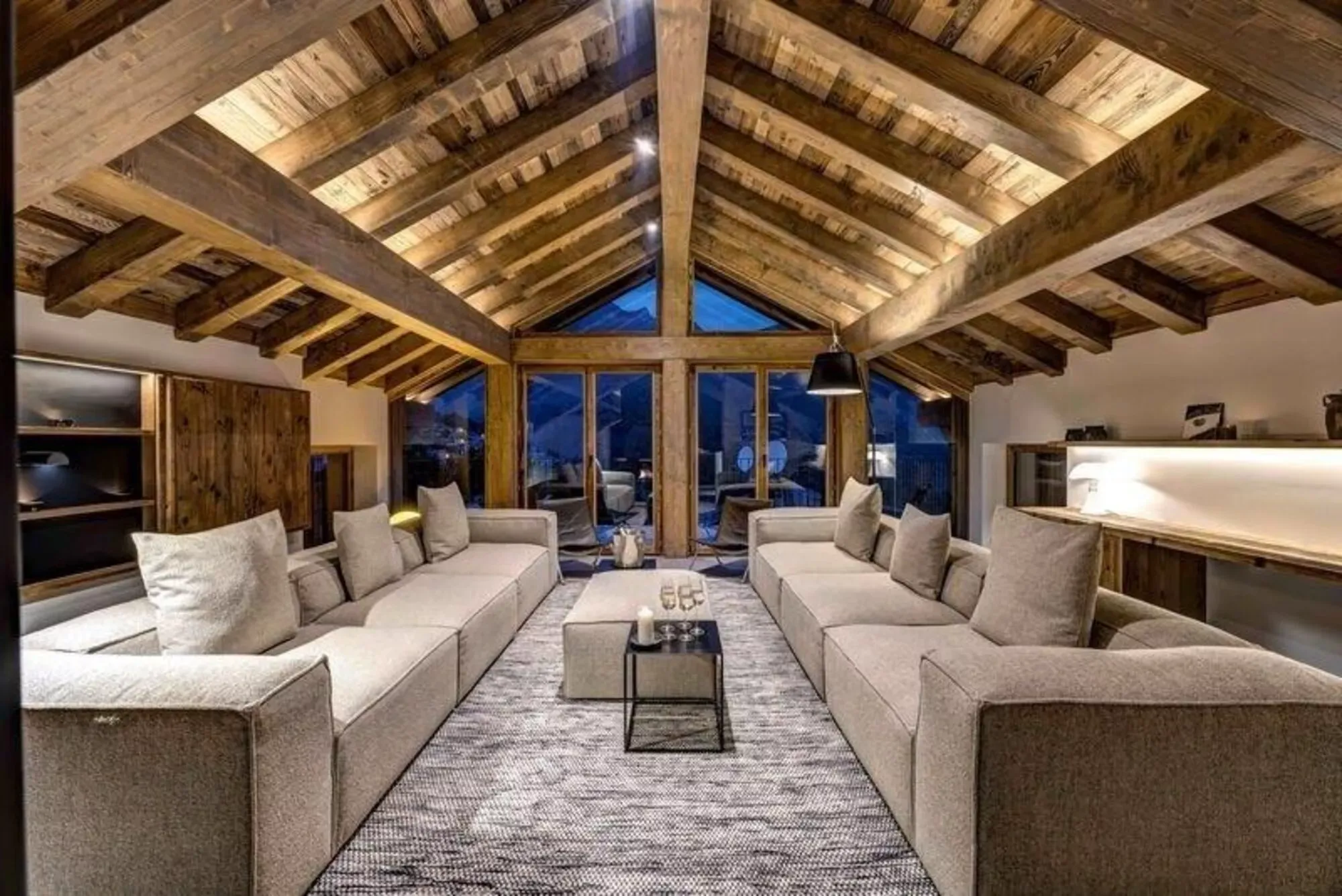 Living room beneath vaulted timber ceiling at dusk