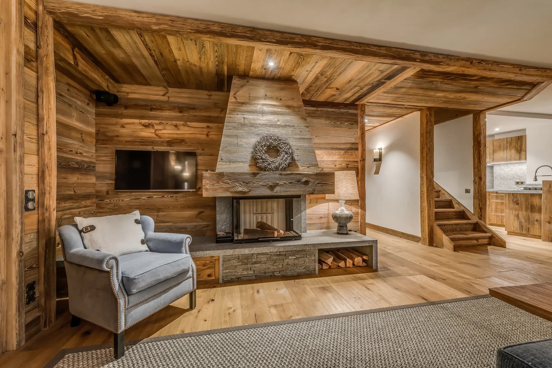 Fireplace and lounge chair beneath timber beams