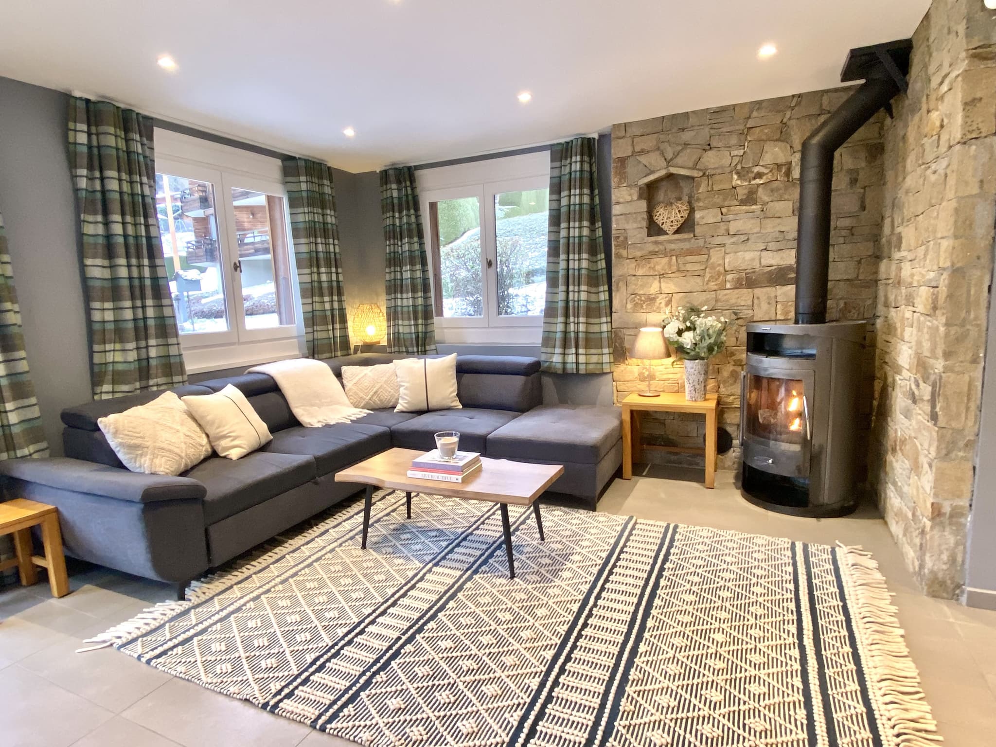 Open-plan lounge with a log burner and stone feature wall