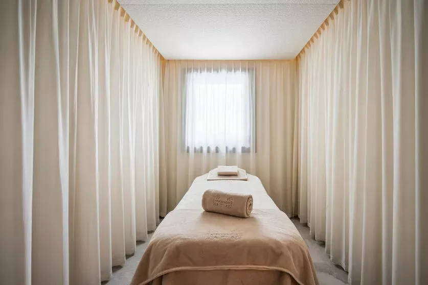 Private massage room with a treatment table and curtained walls