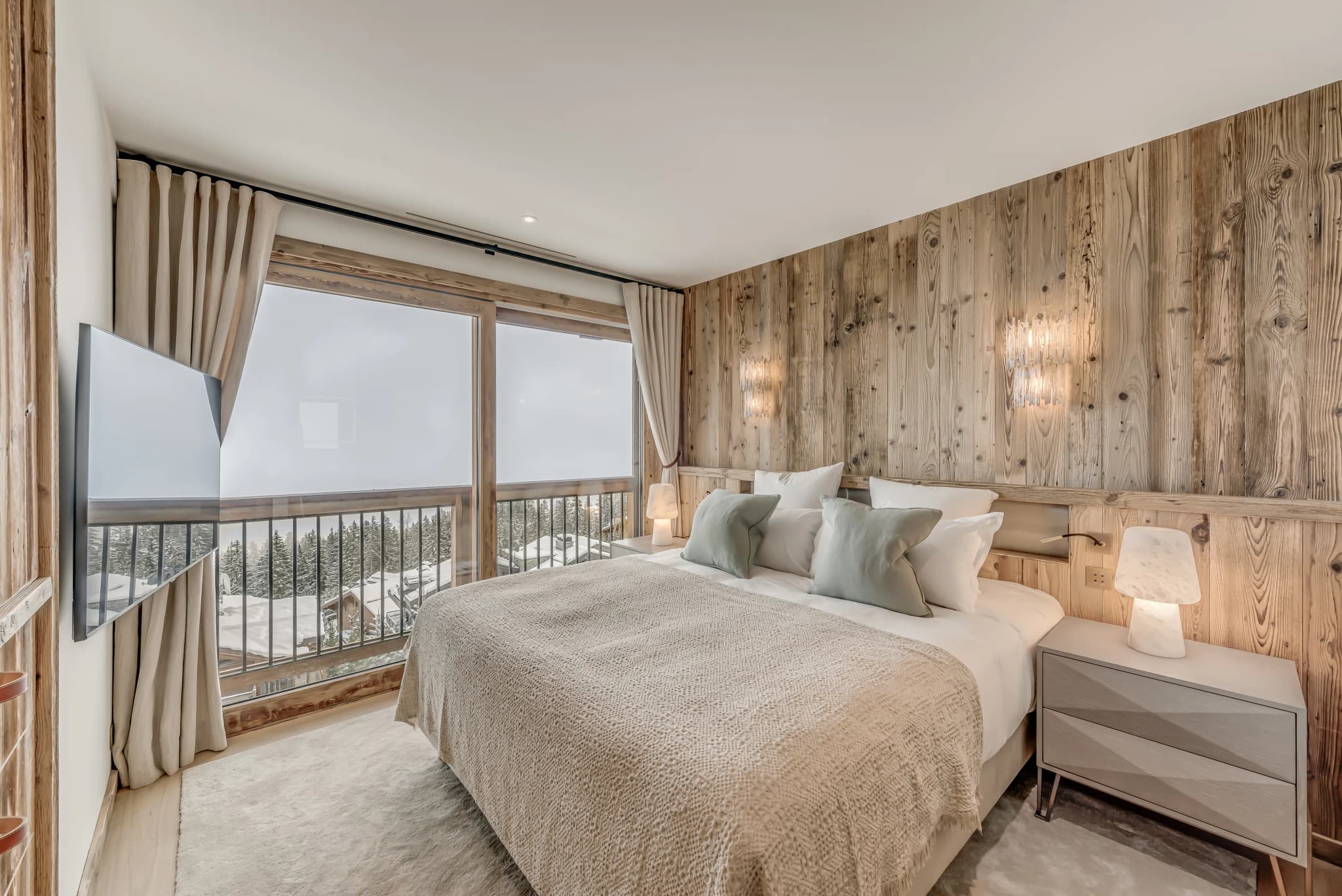 Double bedroom beside mountain-facing windows