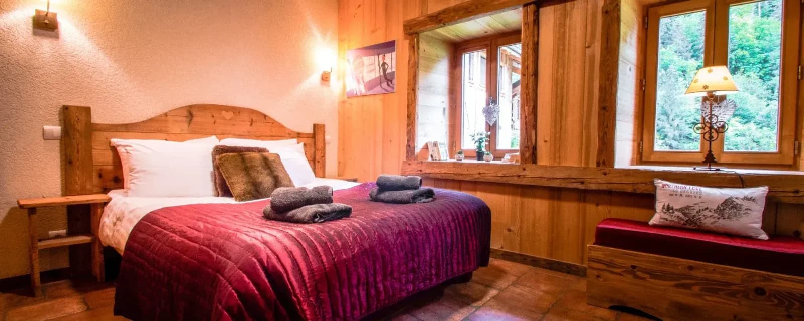 King or twin bedroom with a red bedspread and wide windows