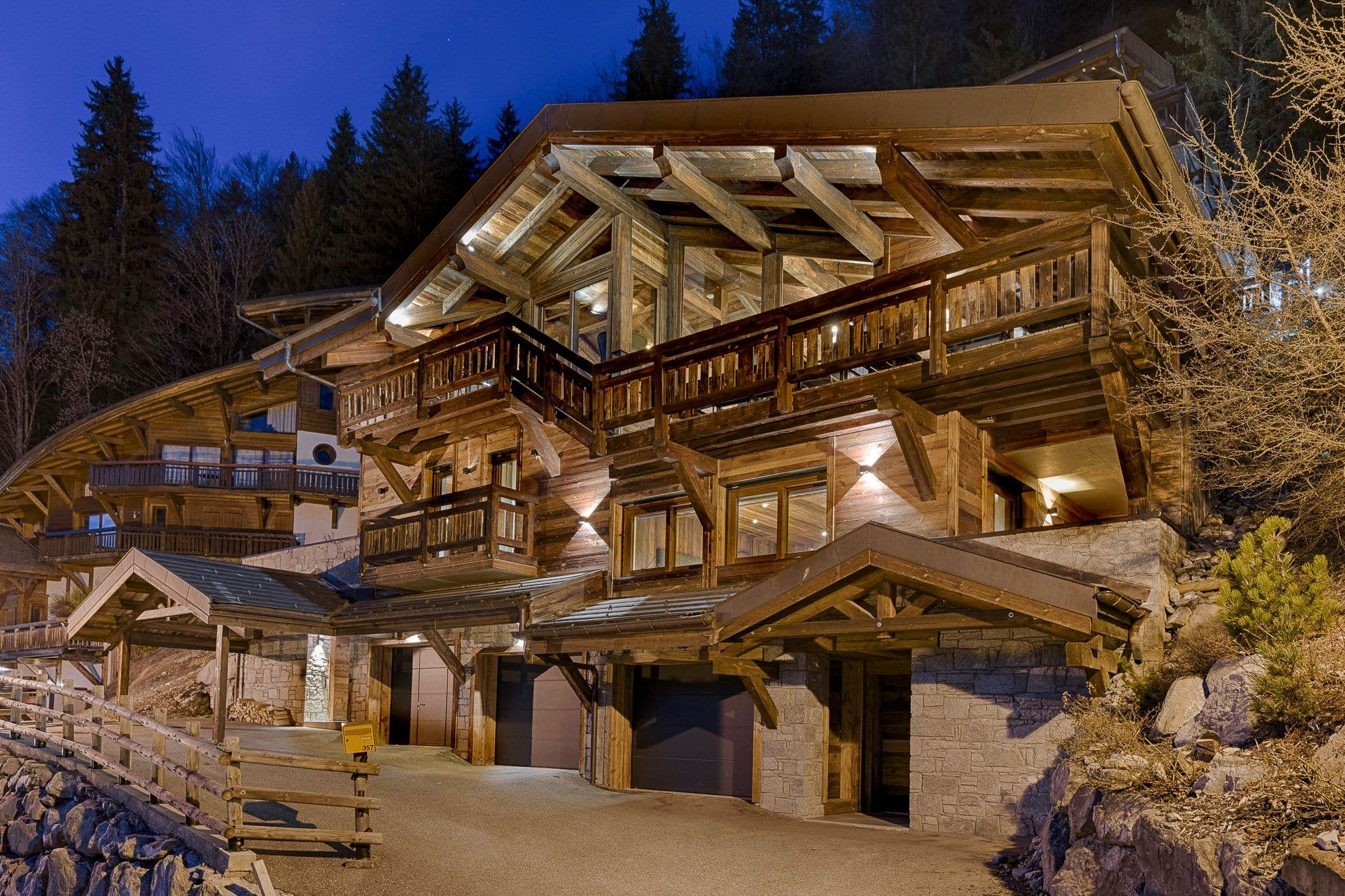 Illuminated chalet exterior on a snowy hillside at dusk