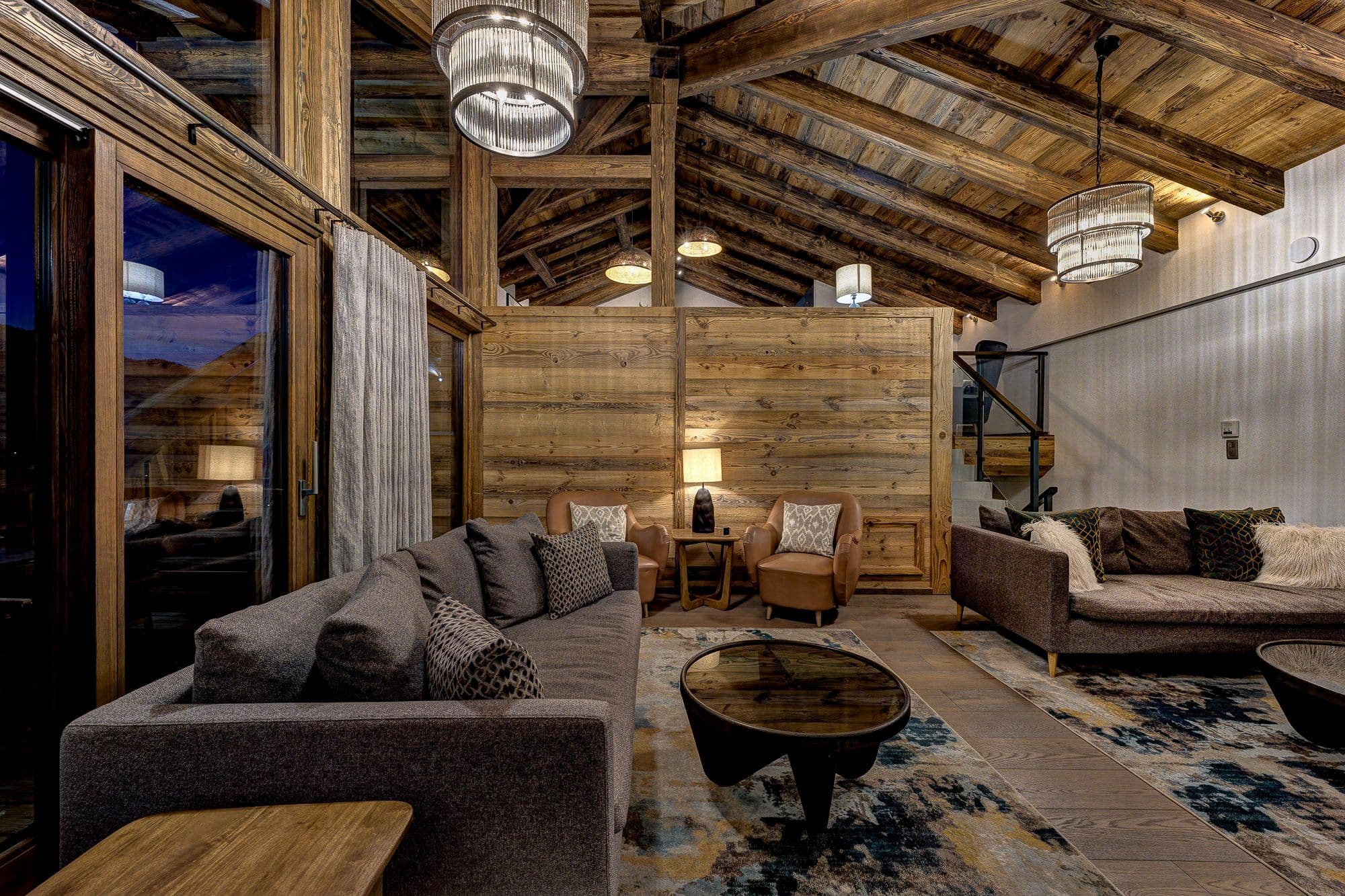Timber-lined lounge with sofas, armchairs and a vaulted ceiling
