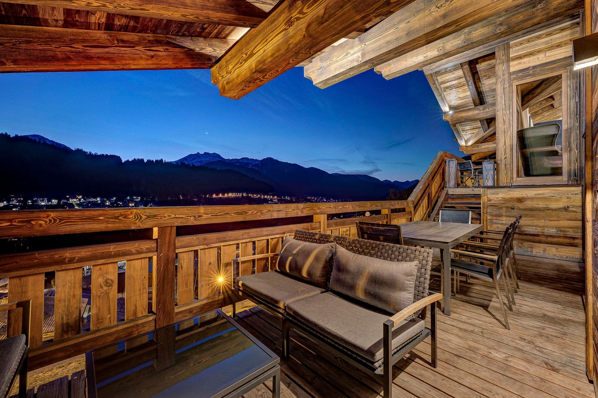 Furnished wooden terrace with mountain and valley views at dusk
