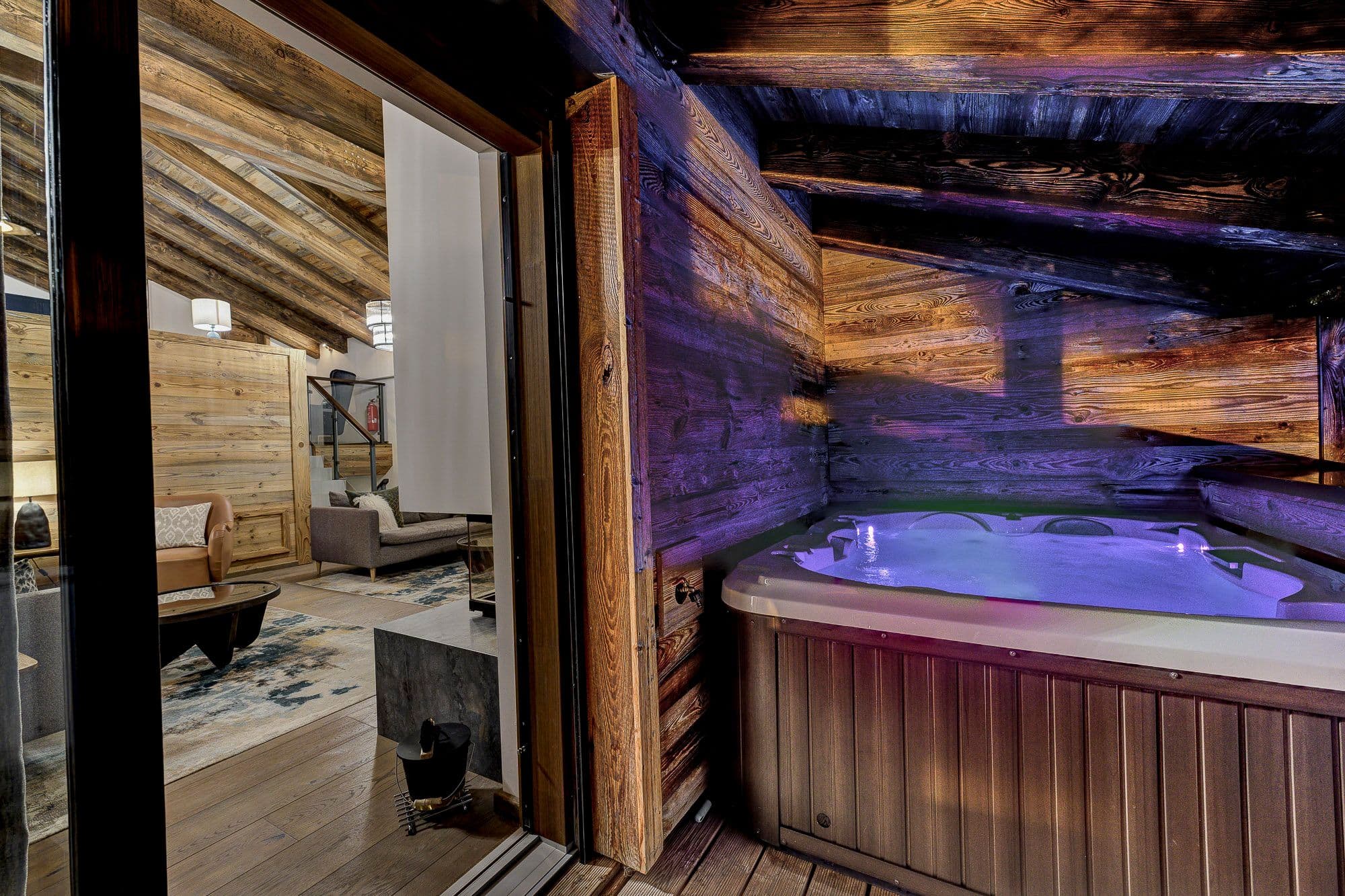 Four-person outdoor hot tub in a sheltered timber alcove