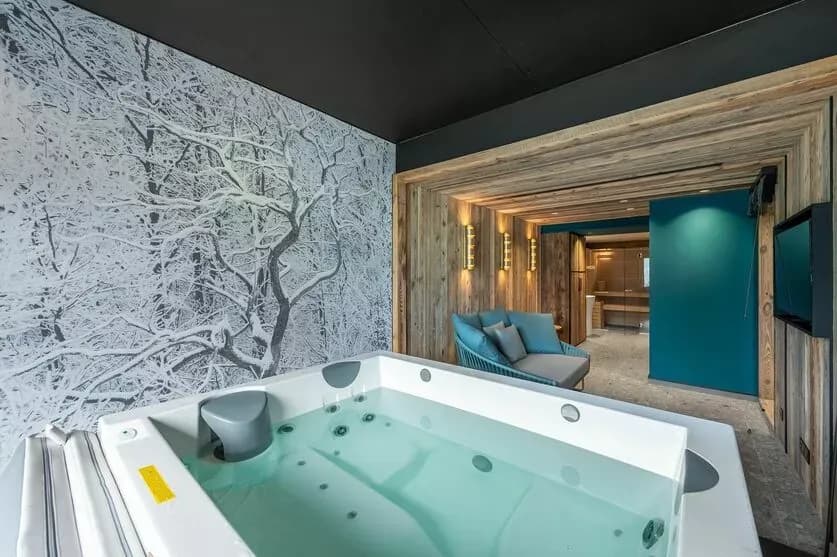 Indoor jacuzzi with timber steps and an adjoining corridor