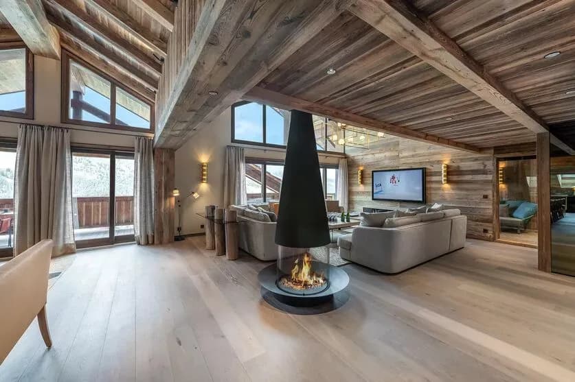 Living room seating arranged around a suspended fireplace and television