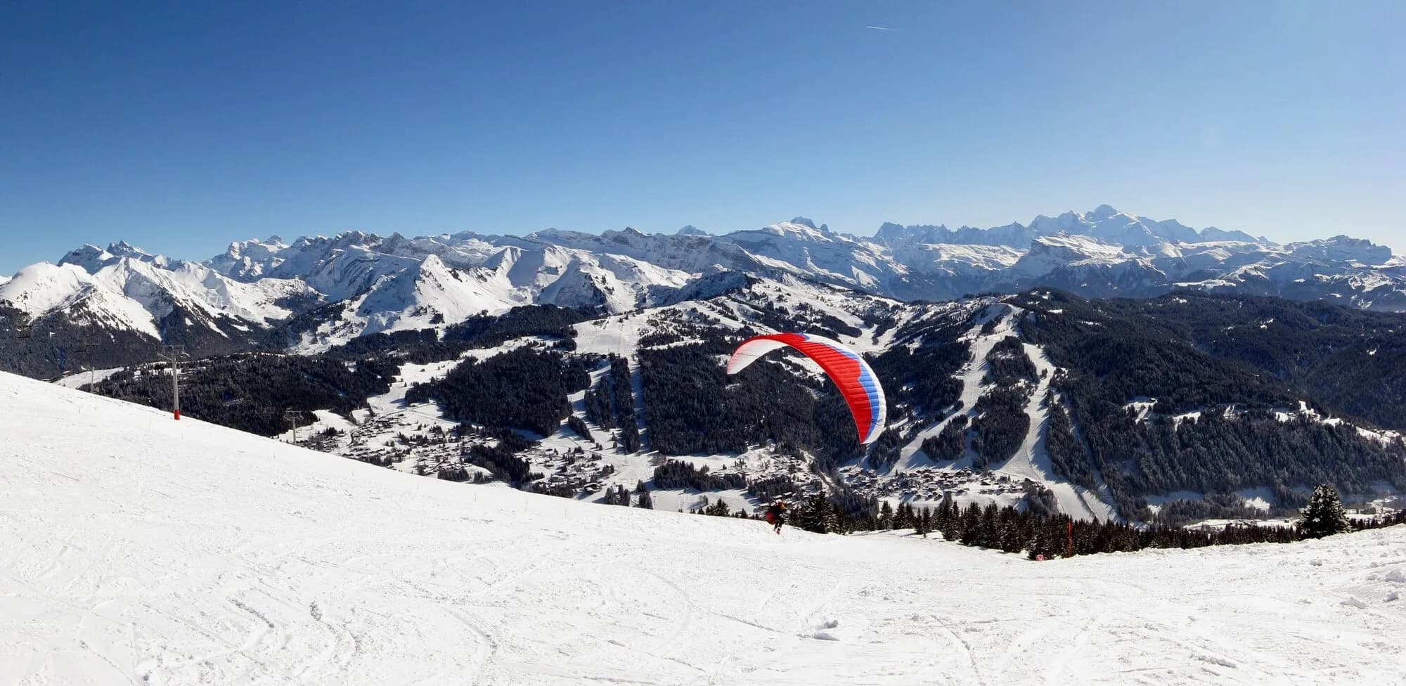 A wide winter view over the Les Gets ski area and village with Mont Blanc on the horizon.