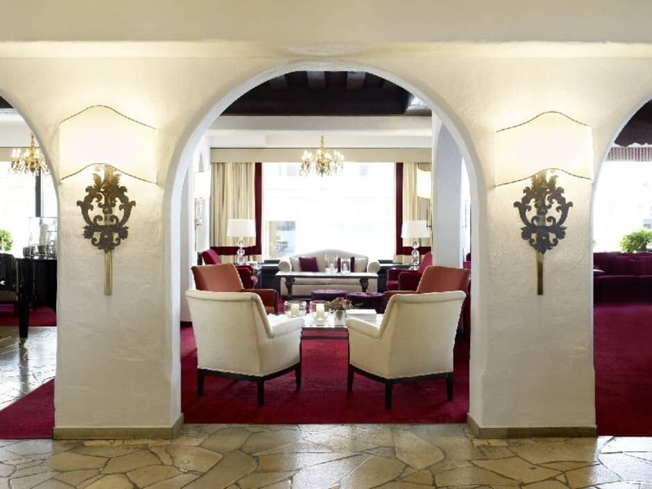 Lounge area with stone floors, archways, and dark wood ceiling beams
