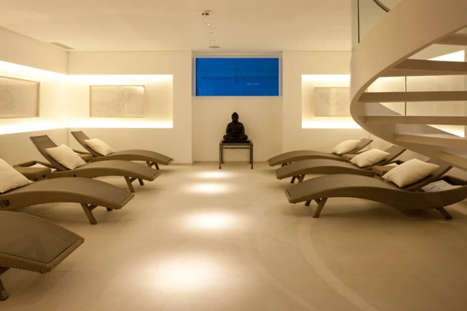 Spa lounge with six ergonomic recliners and spiral staircase access
