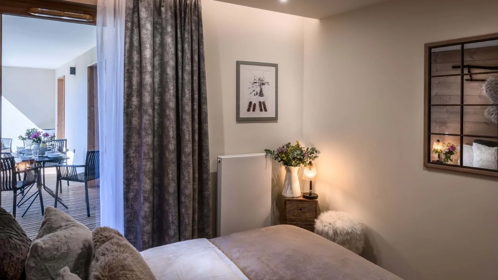 Double bedroom with balcony access and outdoor dining beyond