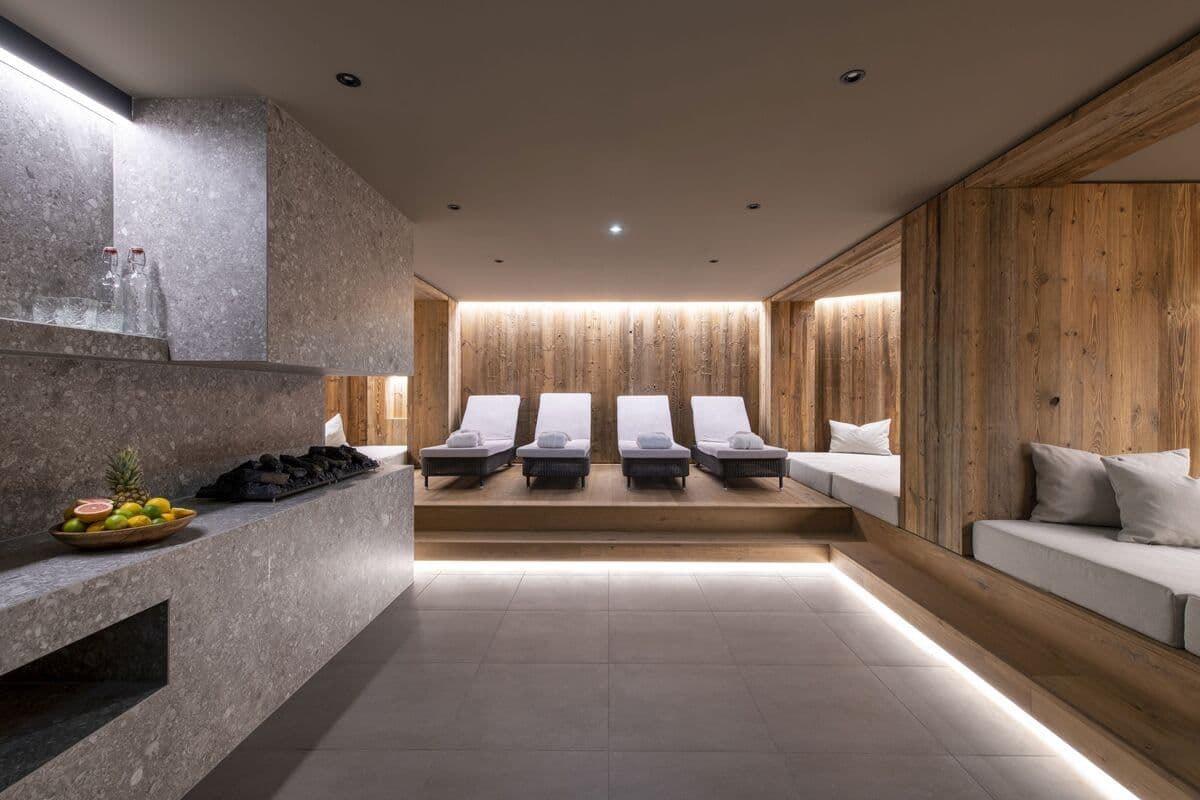 Spa relaxation room with four loungers, daybeds, and stone refreshment bar