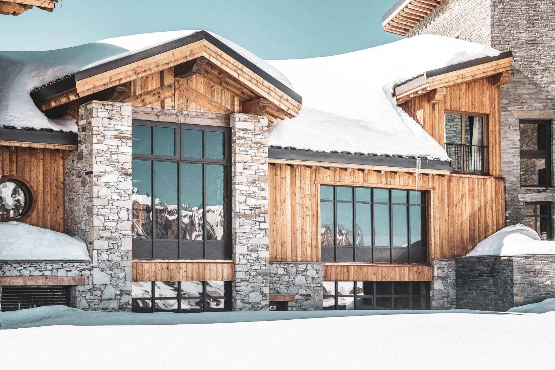 Ski-in exterior with floor-to-ceiling windows and mountain reflections