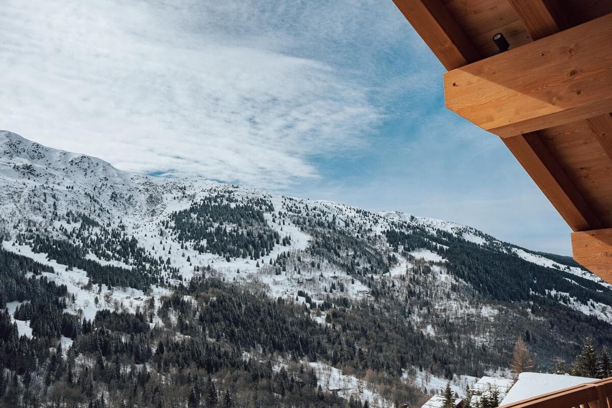 Balcony view of snow-covered peaks and wooded ski runs