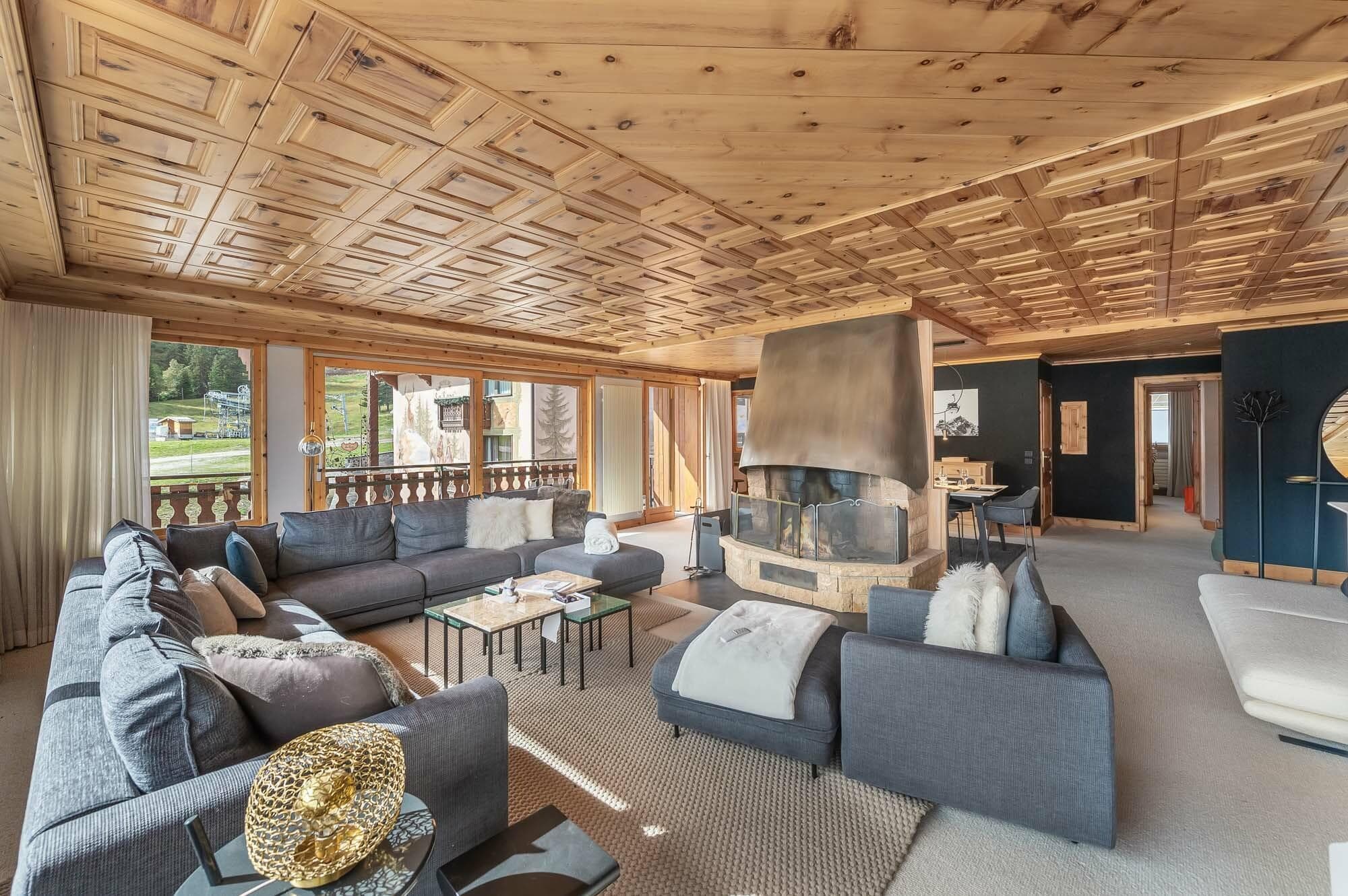Living room seating arranged around the central wood fireplace