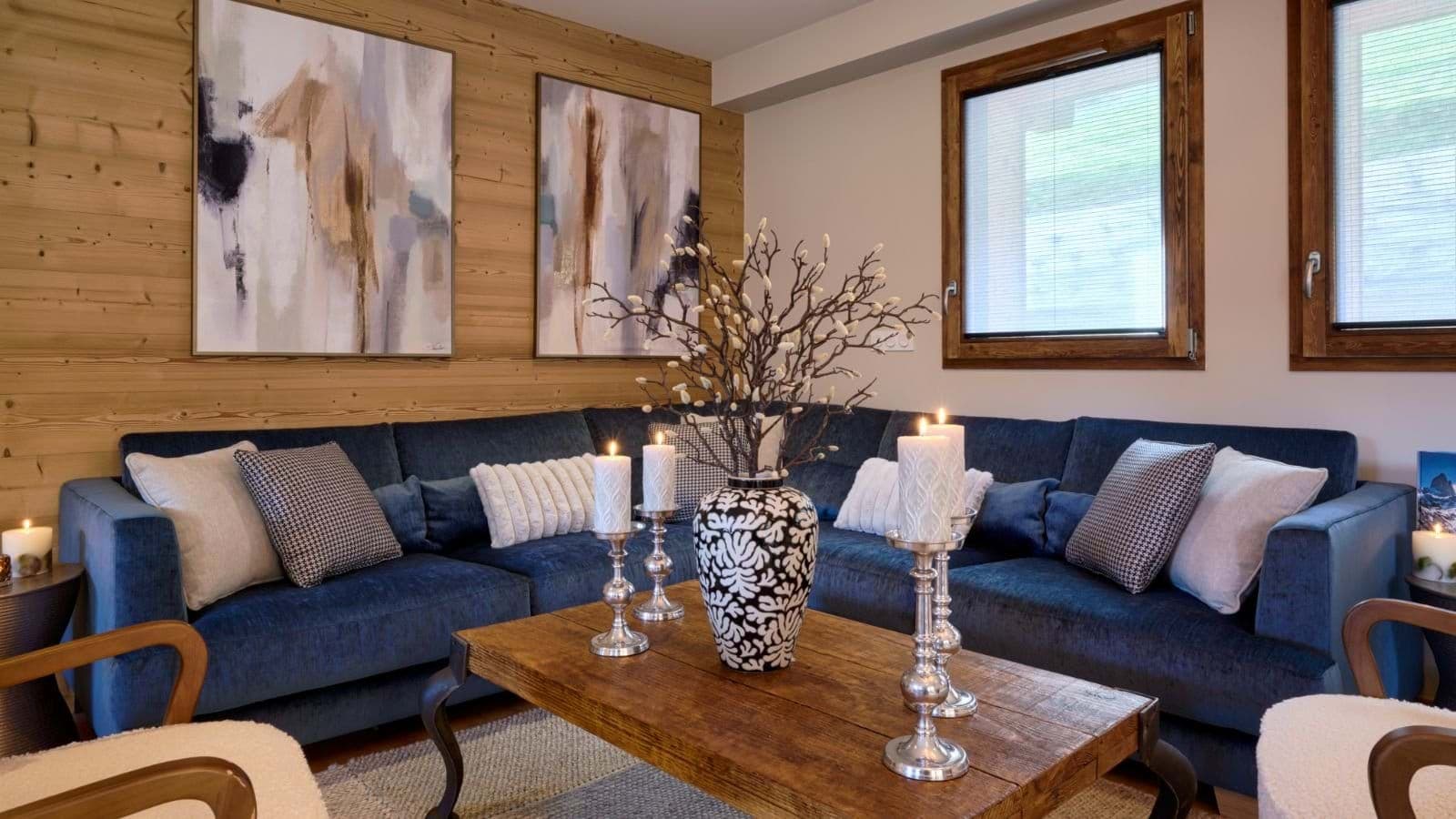 Open-plan living area with an L-shaped sofa and timber feature wall