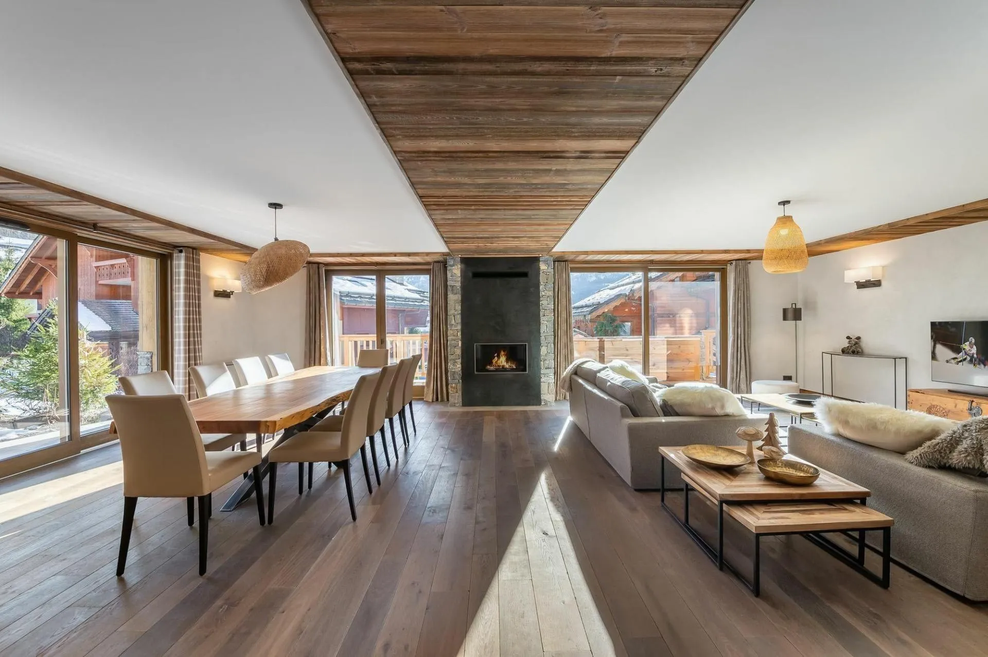 Open-plan lounge and dining area with a central stone fireplace