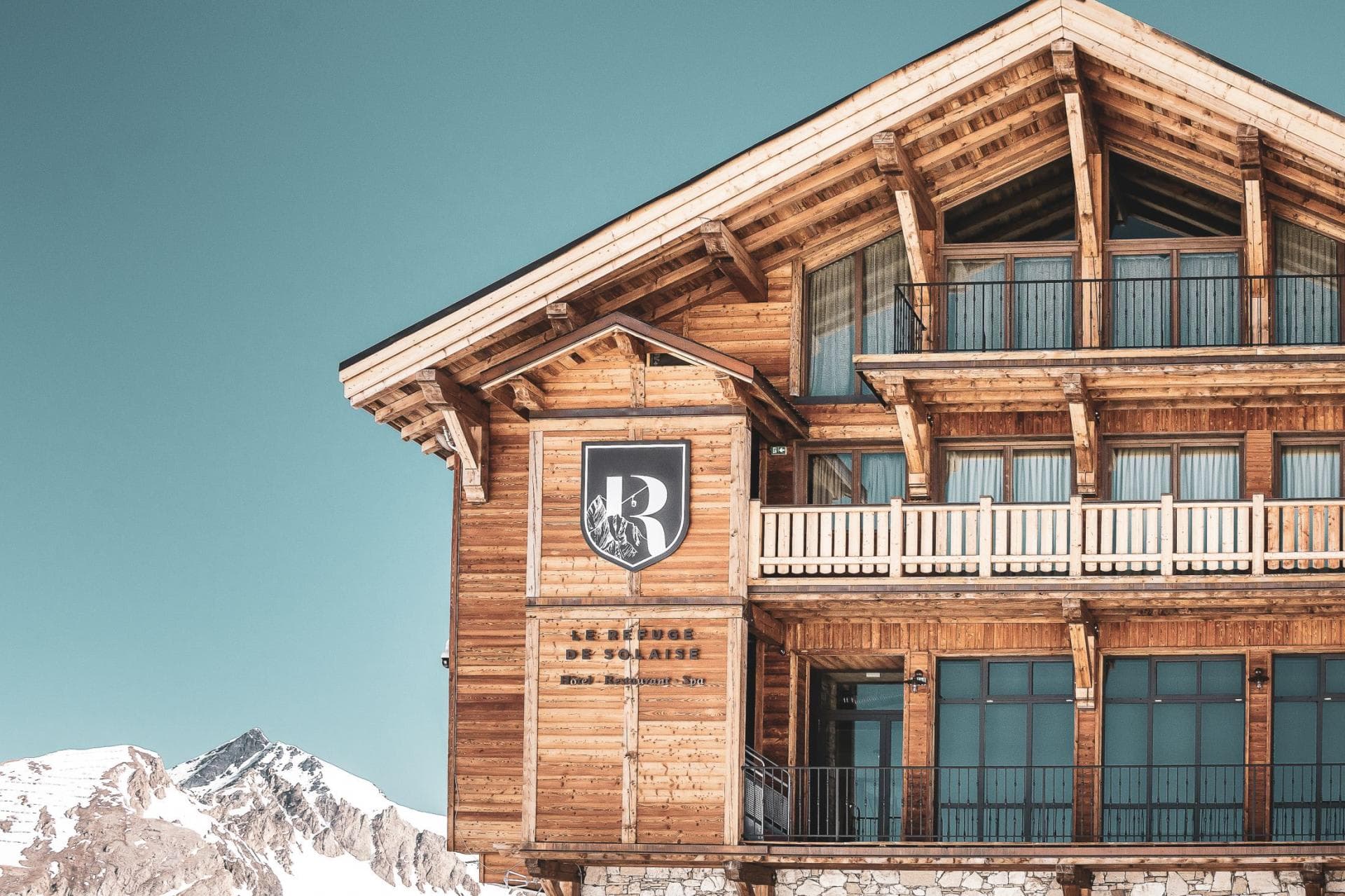Timber lodge exterior featuring private balconies and high-altitude mountain views