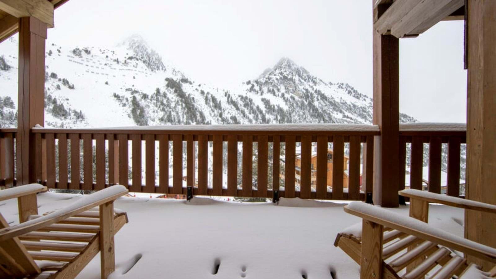 Covered balcony with lounge seating and panoramic mountain views