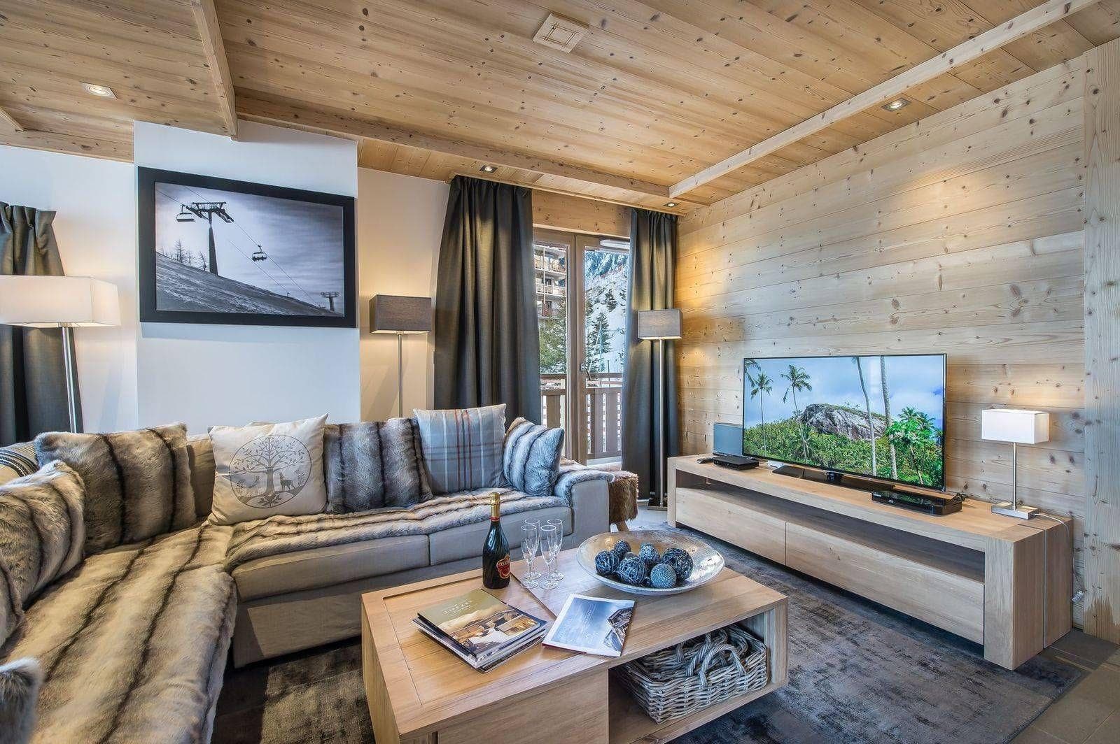 Living room with corner sofa, timber walls and television