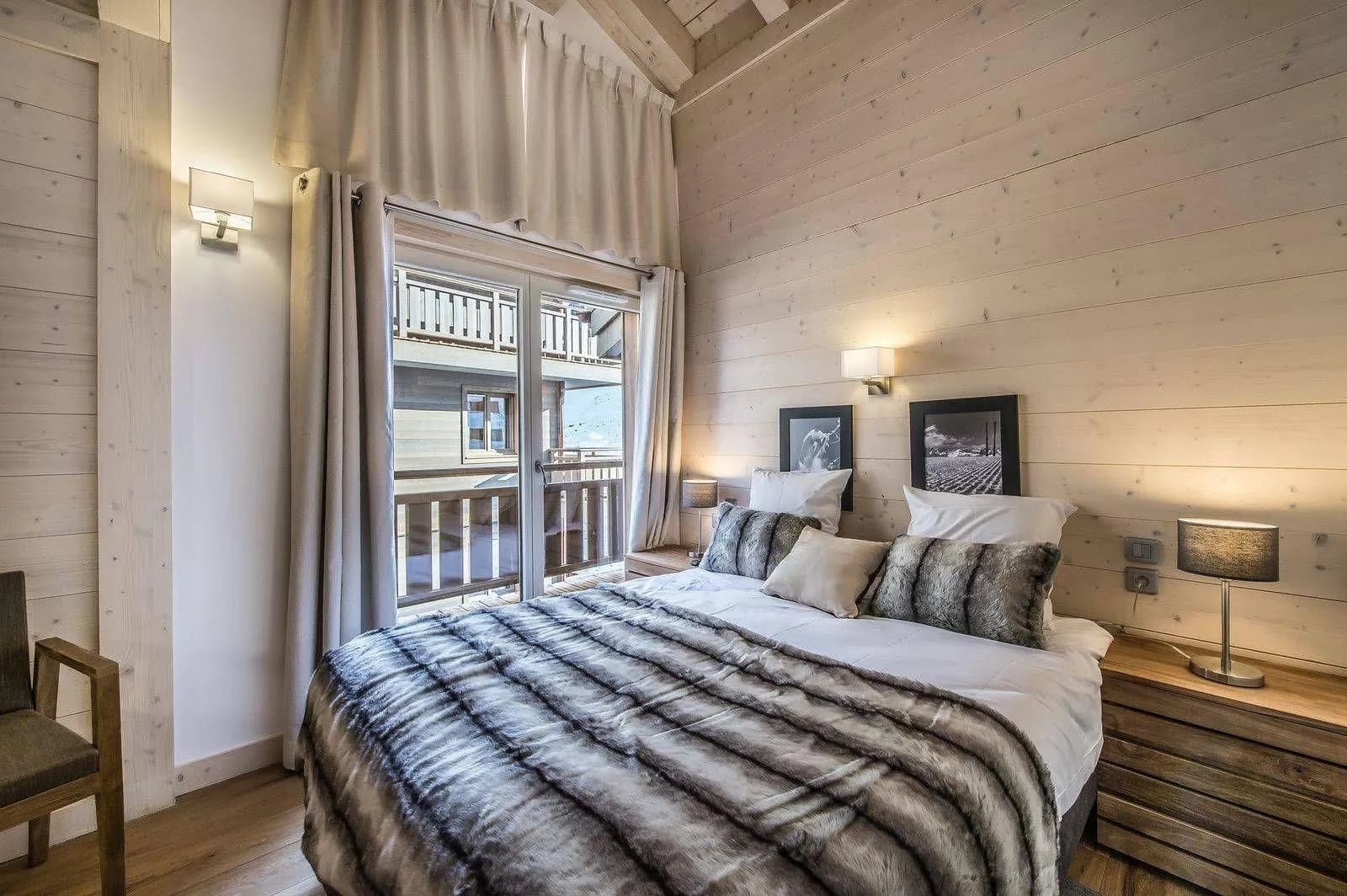 Double bedroom with a timber ceiling and mountain-facing window