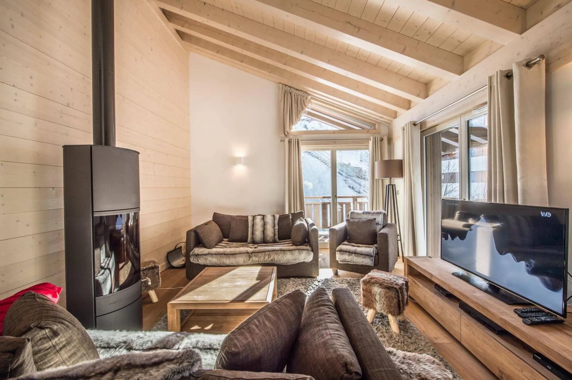 Top-floor living room with a wood stove, television and balcony doors