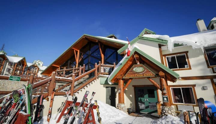 Ski-in/ski-out lodge entrance with equipment racks and direct slope access