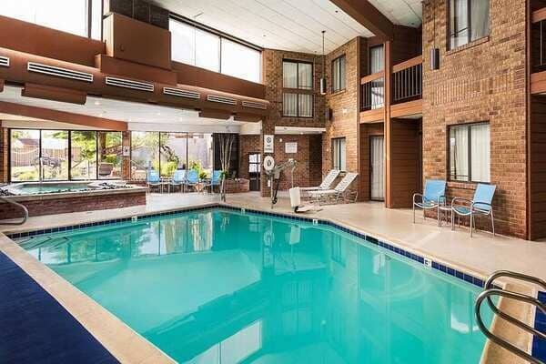 Indoor heated pool and hot tub with poolside lounge seating