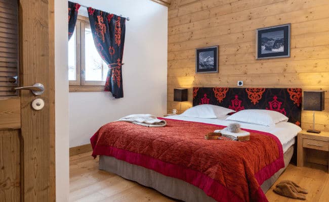 Bedroom with king bed and wood-paneled walls