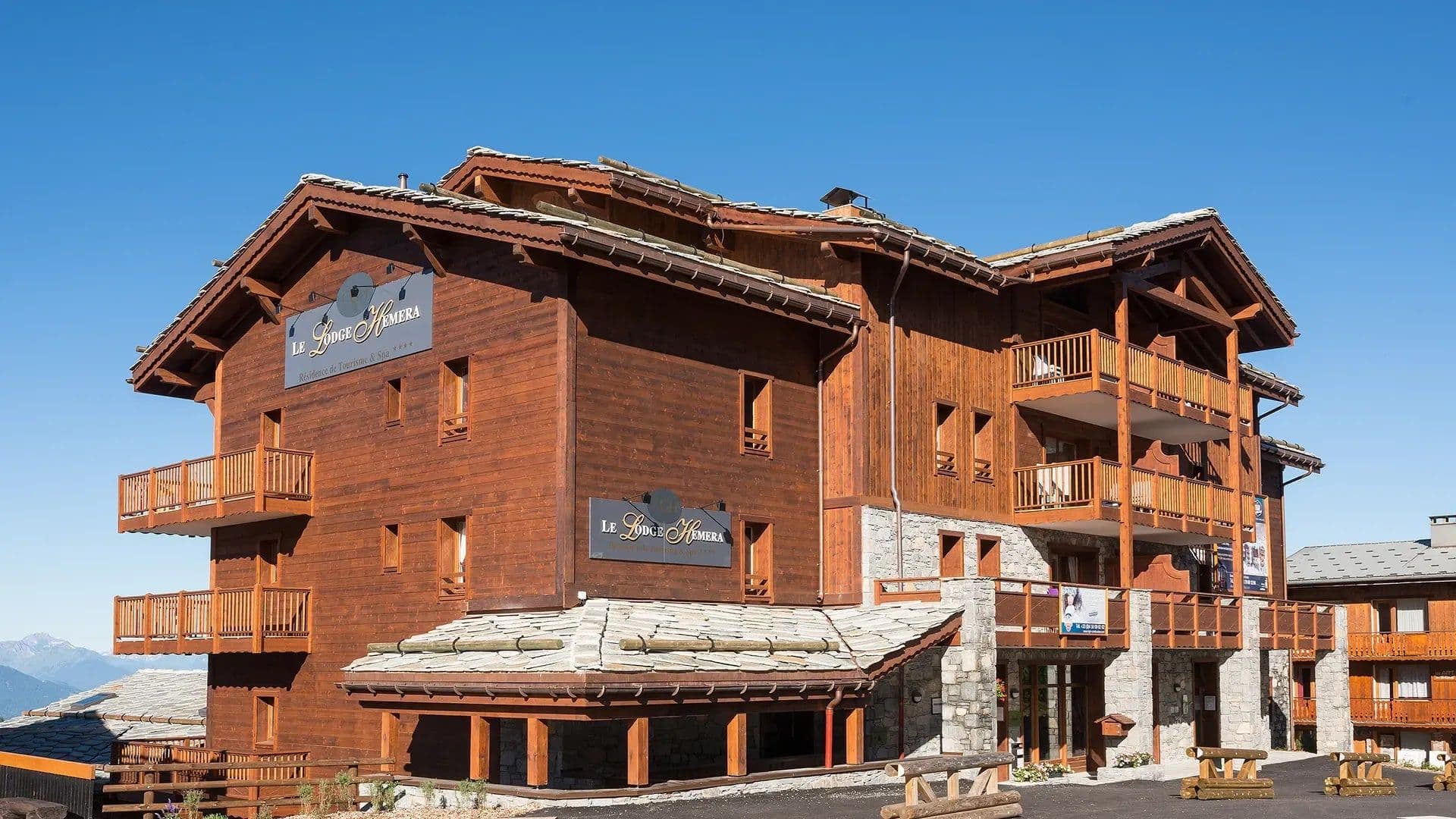 Chalet exterior featuring private balconies and stone-accented ground floor