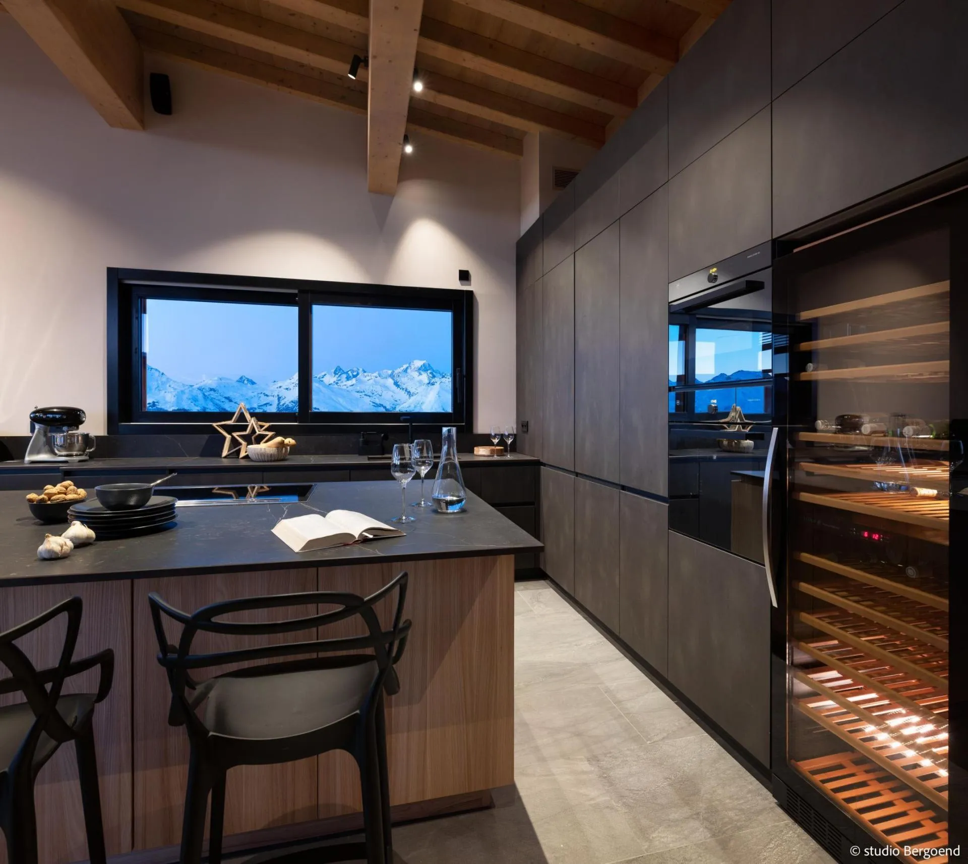 Open-plan kitchen with wine fridge and mountain-view window