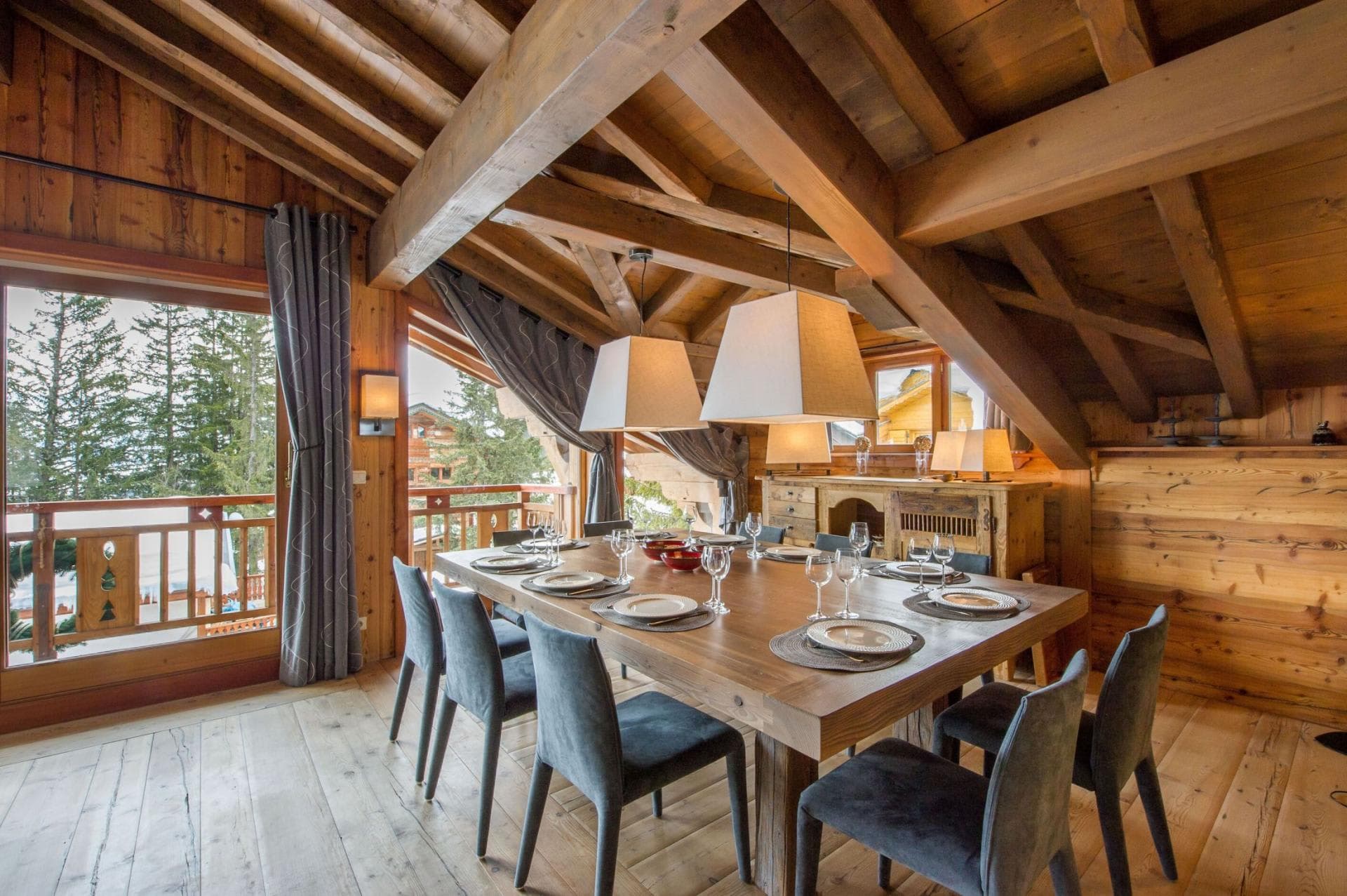 Dining table beside balcony doors beneath a timber ceiling