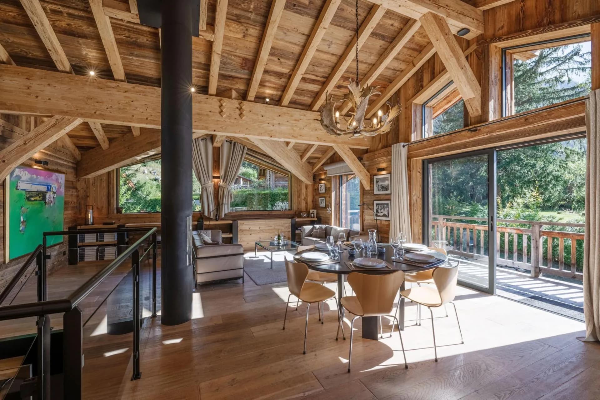 Open-plan dining and living area beneath exposed timber beams