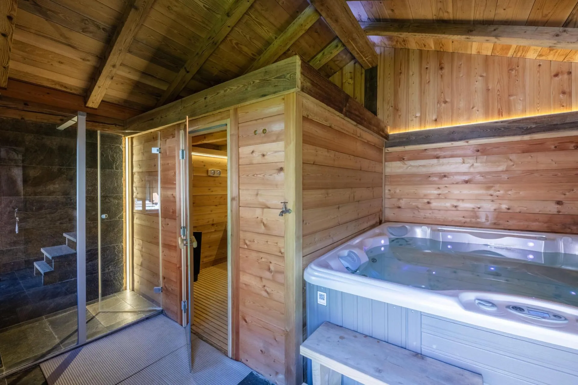 Indoor Jacuzzi beside the glass-fronted sauna in the private spa mazot
