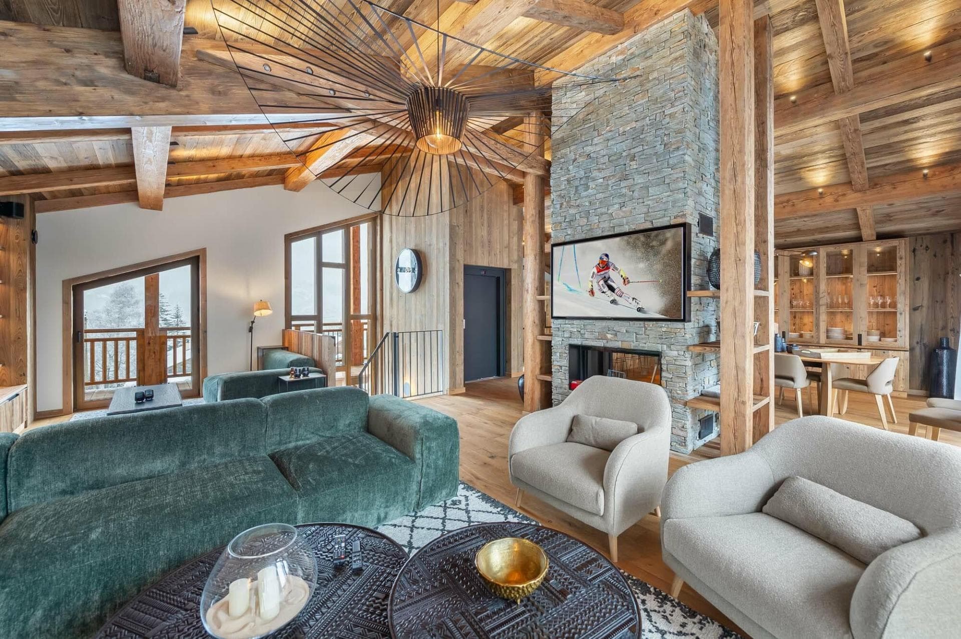 Open-plan living area with green sectional seating, timber ceiling and balcony access