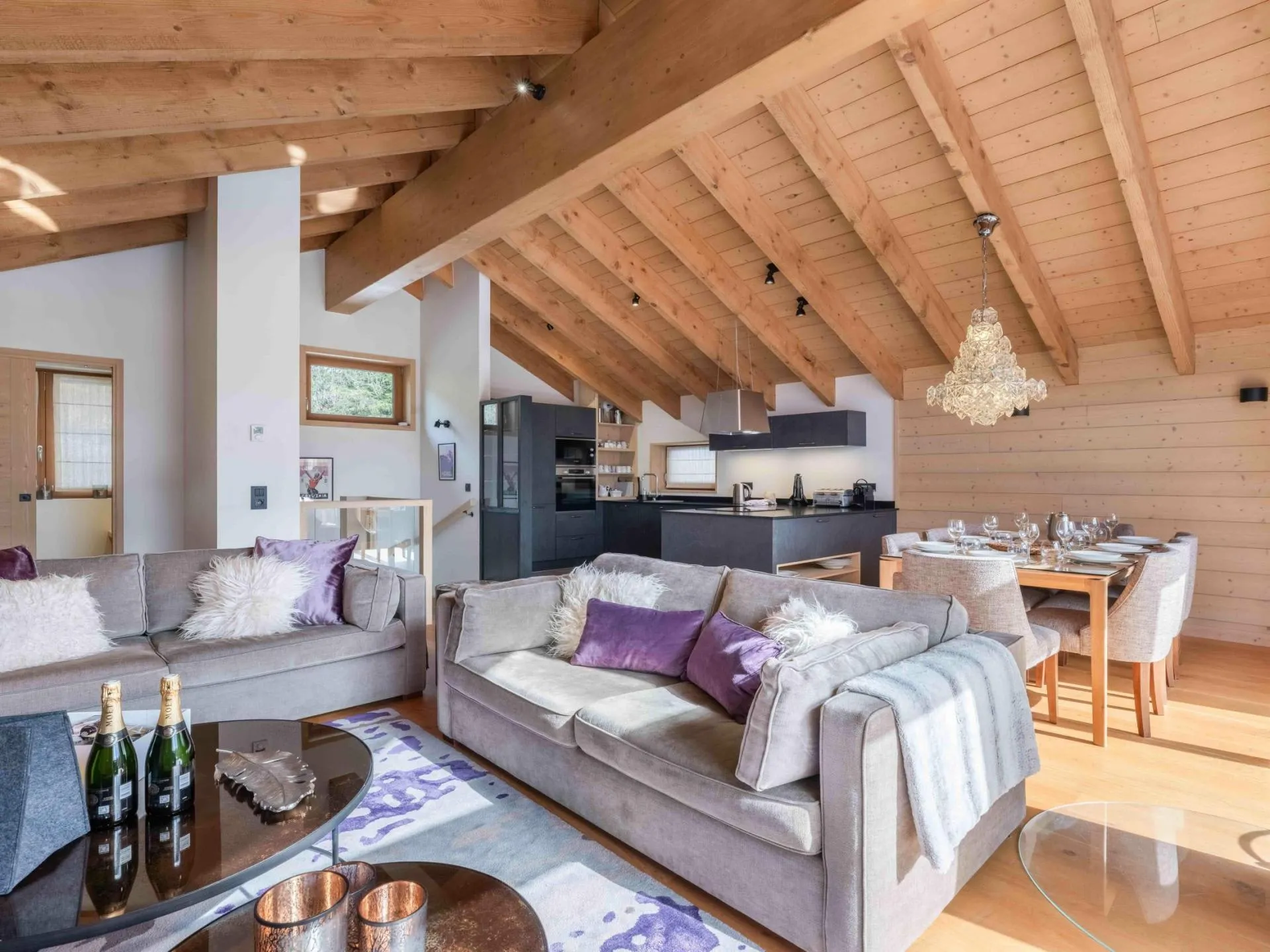 Open-plan lounge and dining area beneath vaulted timber beams