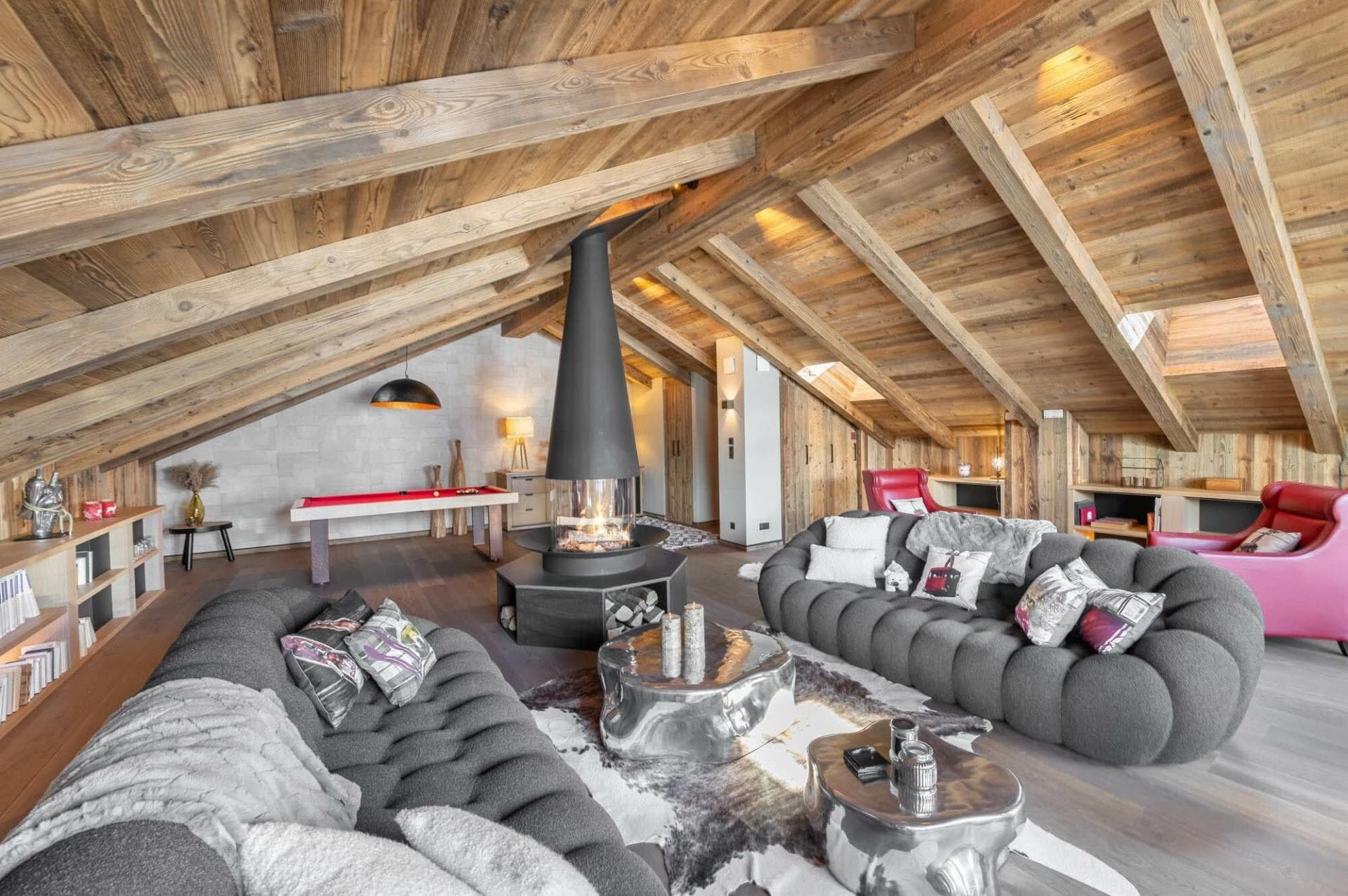 Upper lounge with a central fireplace and vaulted timber ceiling