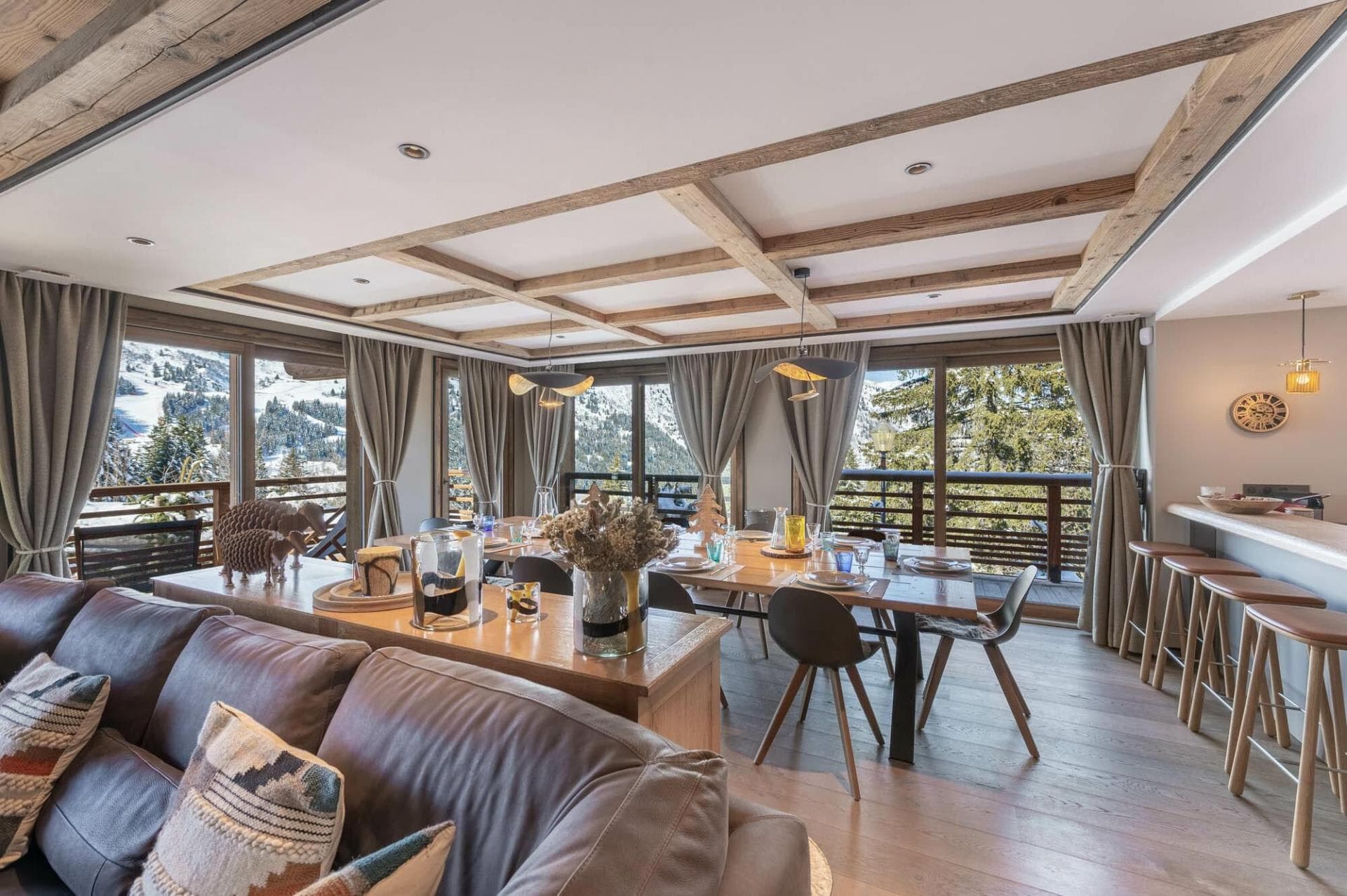 Dining area and lounge opening onto a mountain-facing balcony