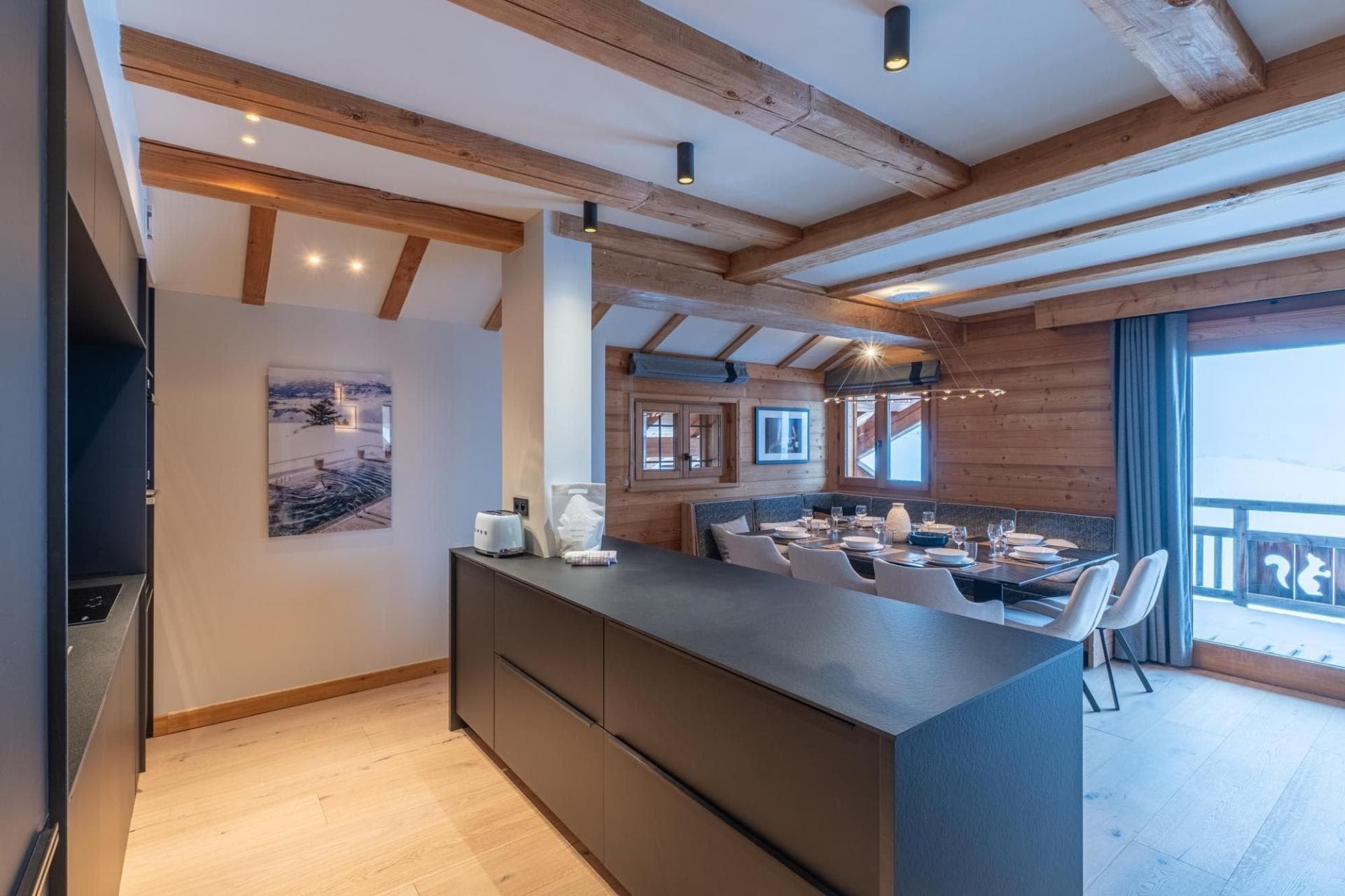 Equipped kitchen island with induction hob beside the dining table