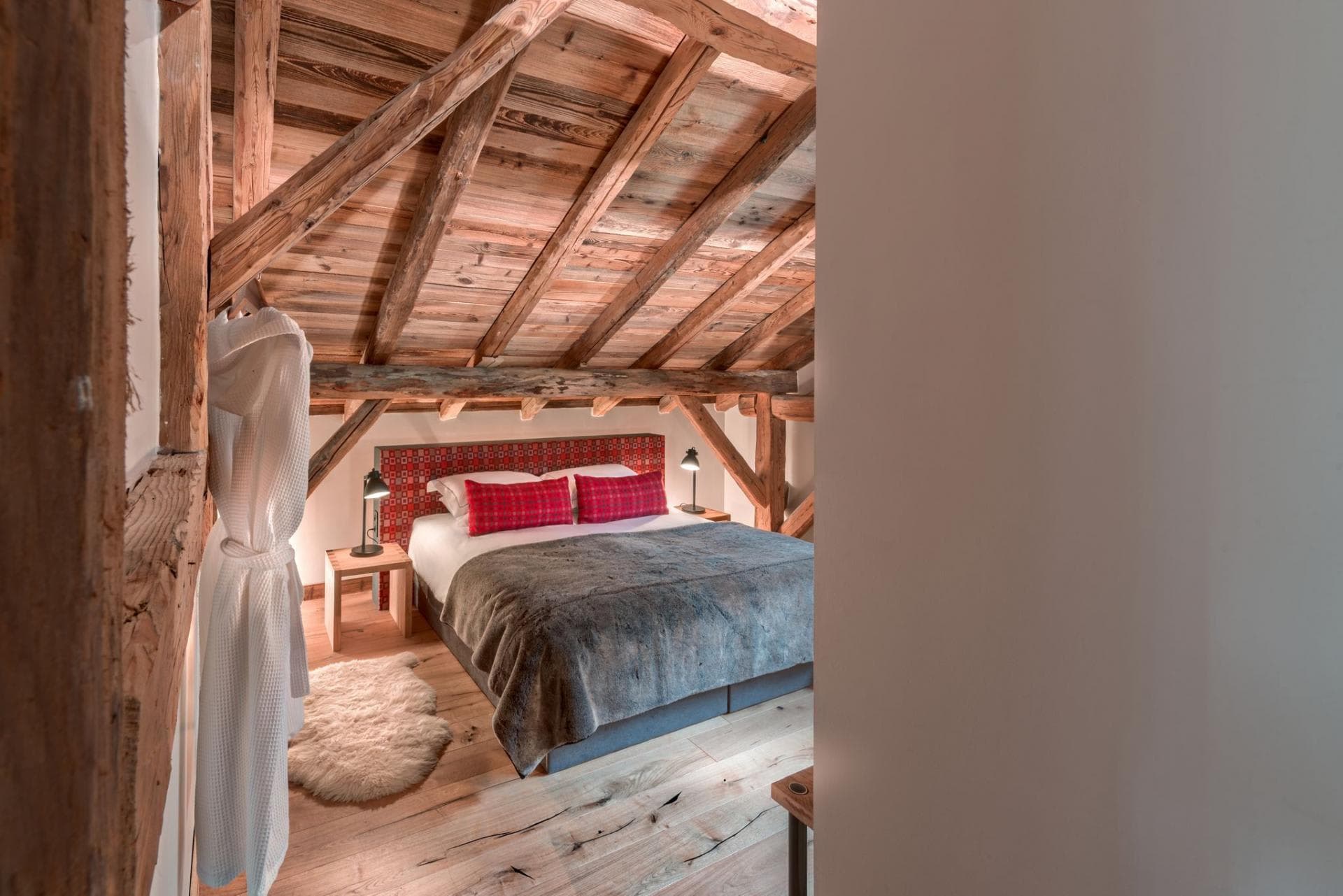 Top-floor master suite with a king-sized bed and exposed timber beams