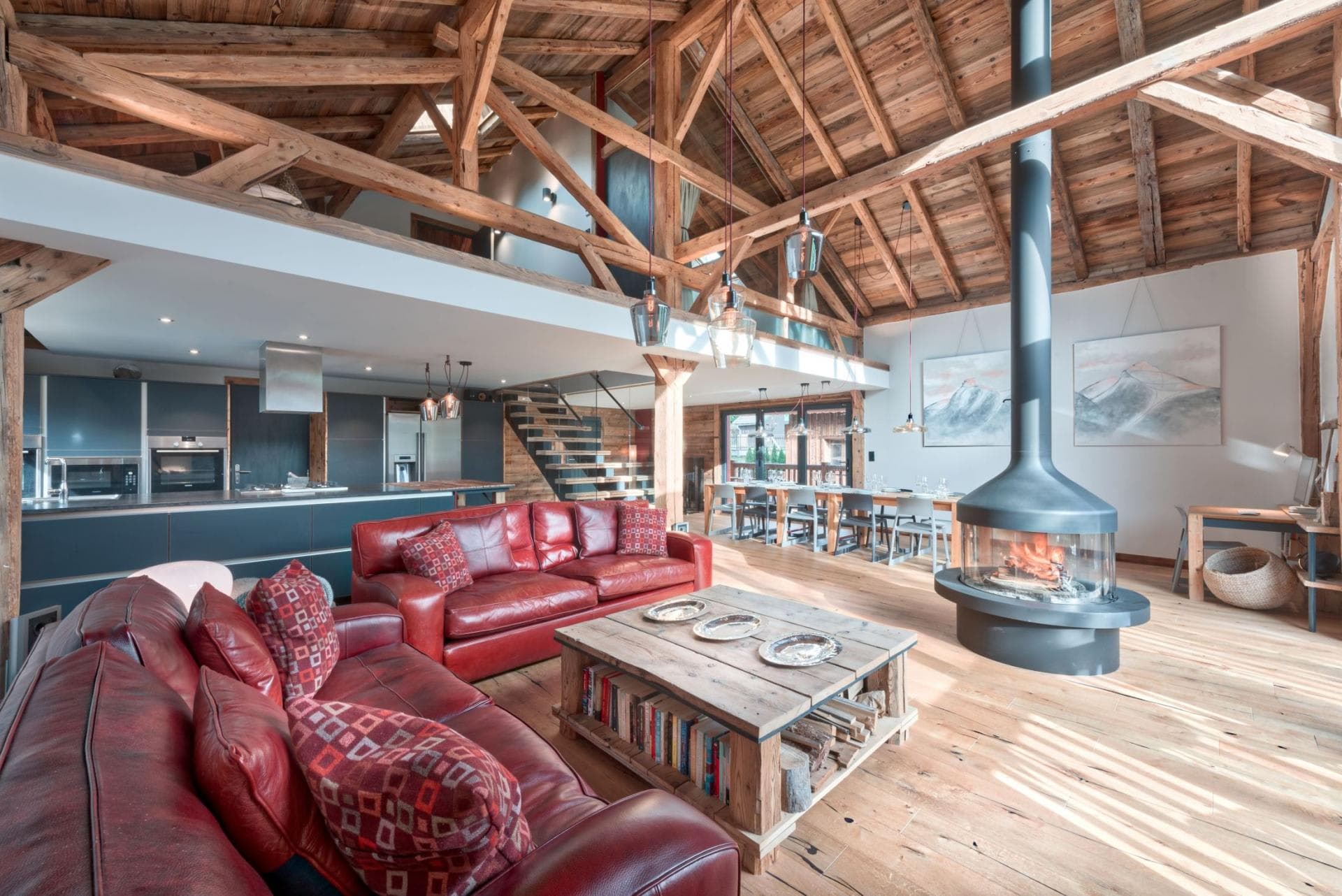 Vaulted open-plan living area with floor-to-ceiling windows and exposed timber